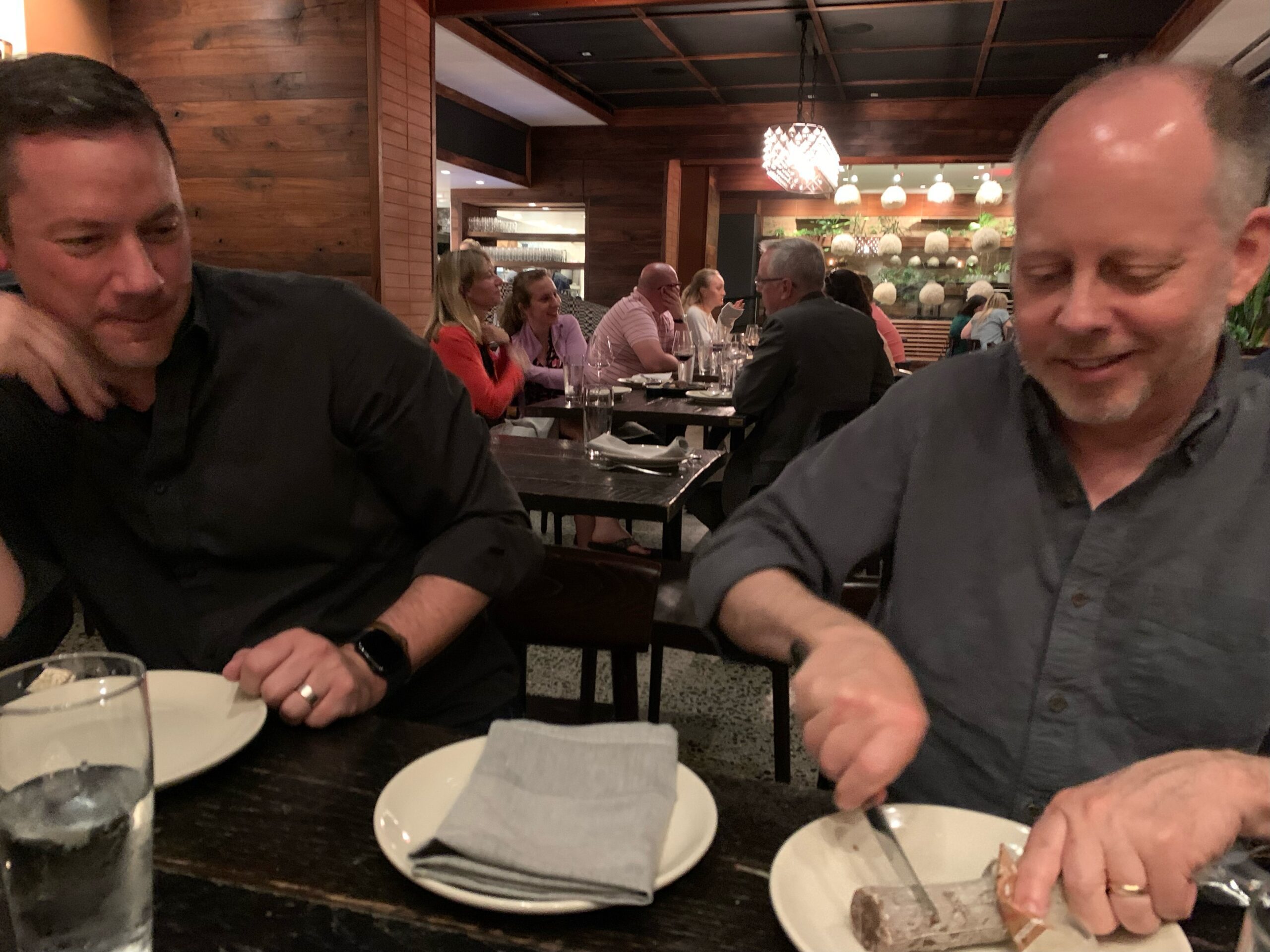 two men one cutting a dessert log